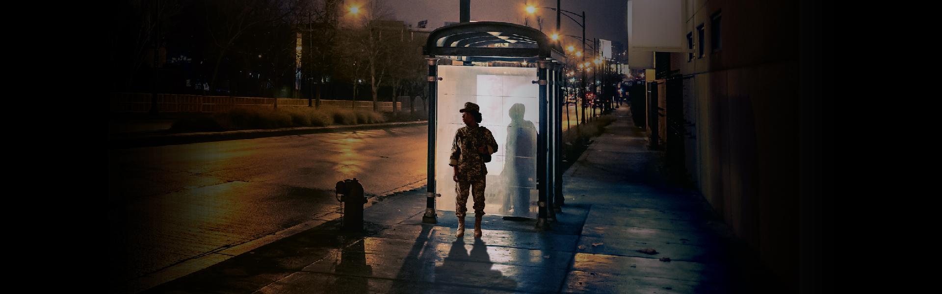 A veteran standing next to a bus stop