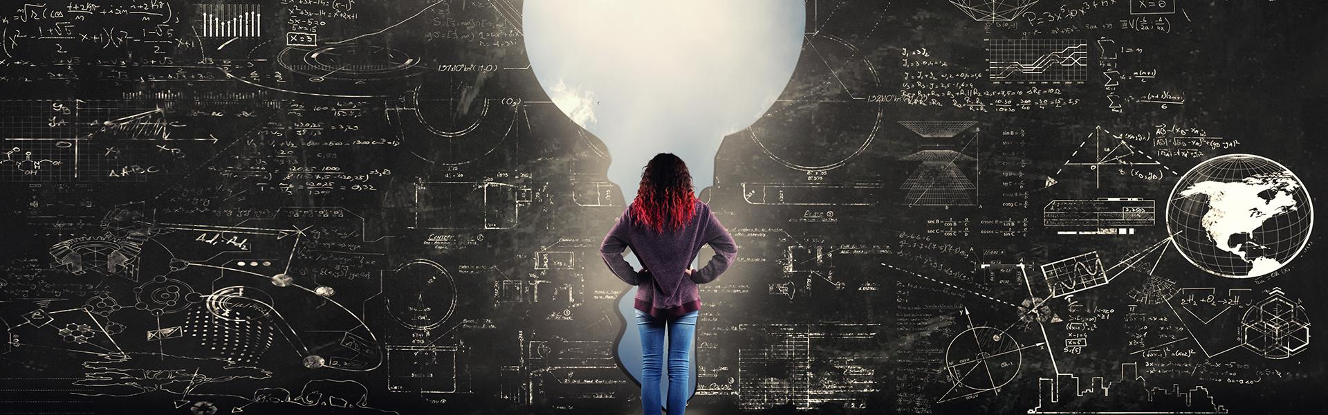 A girl standing in front of a key wall of Math