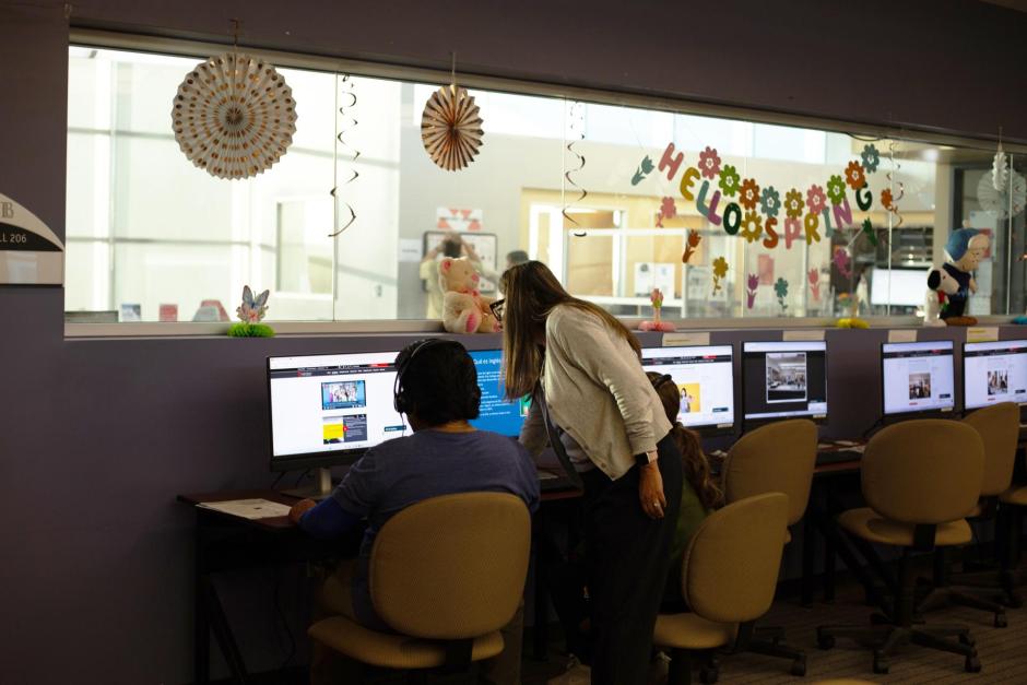 Student assistant aiding two students complete non credit paper application