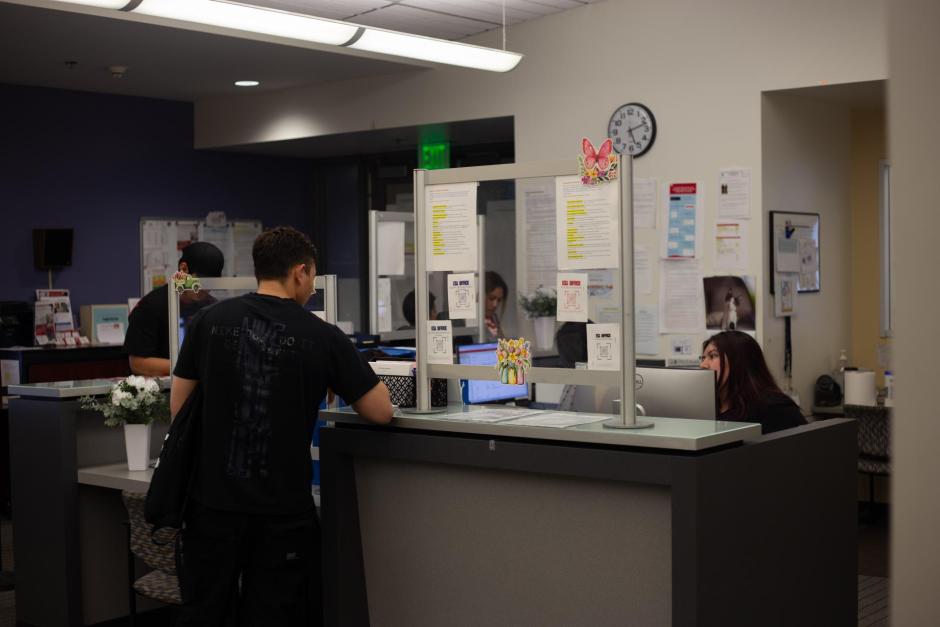 Student assistants helping students at front desk in LL211