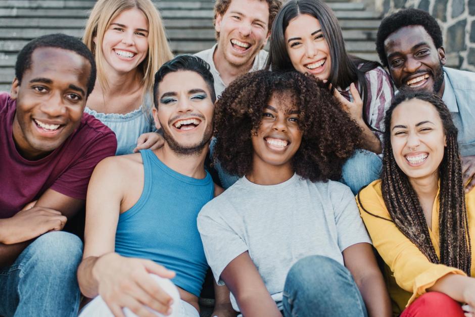 Young group of people smiling on camera having fun outdoor in the city - Focus on african girl face.