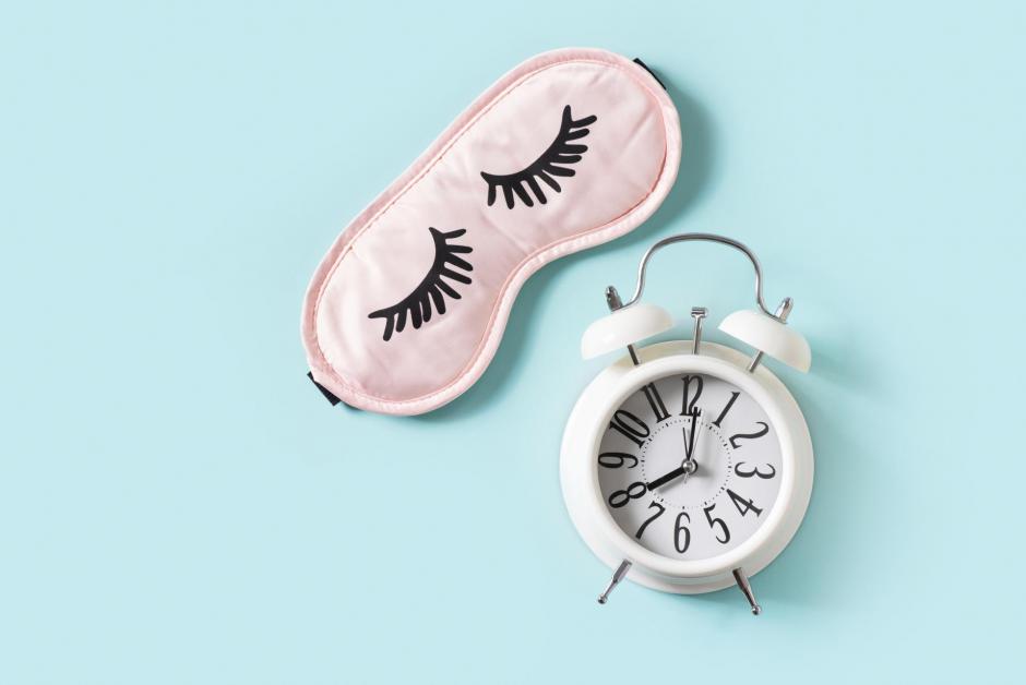 Sleep concept with mask and alarm on blue background, top view, flat lay, copy space