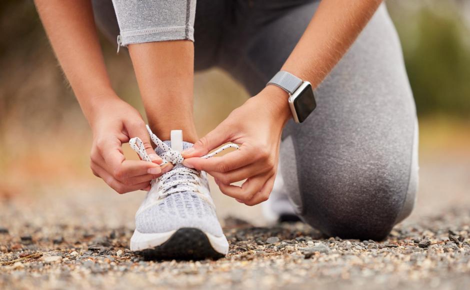 Shoes, fitness and exercise with a sports woman tying her laces before training, running or a workout