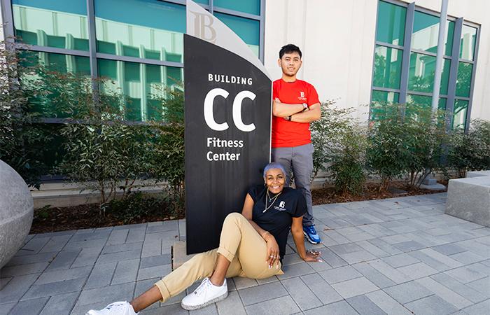 PCC - 2 student posed in front of the CC building - fitness center