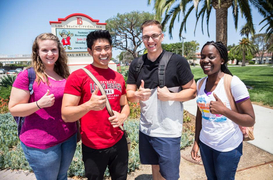 LBCC Students standing in front of Liberal Arts Campus giving thumbs up