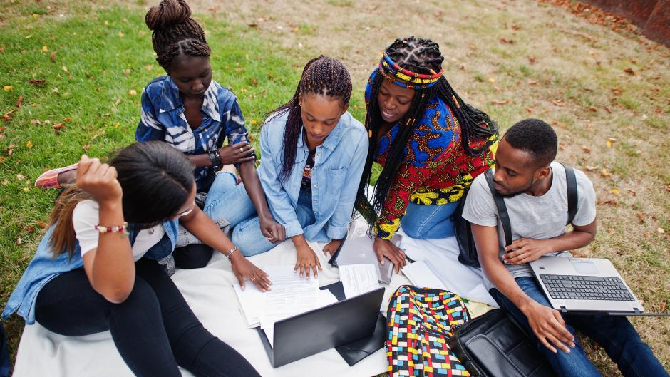 A diverse group of students studying together outdoors.