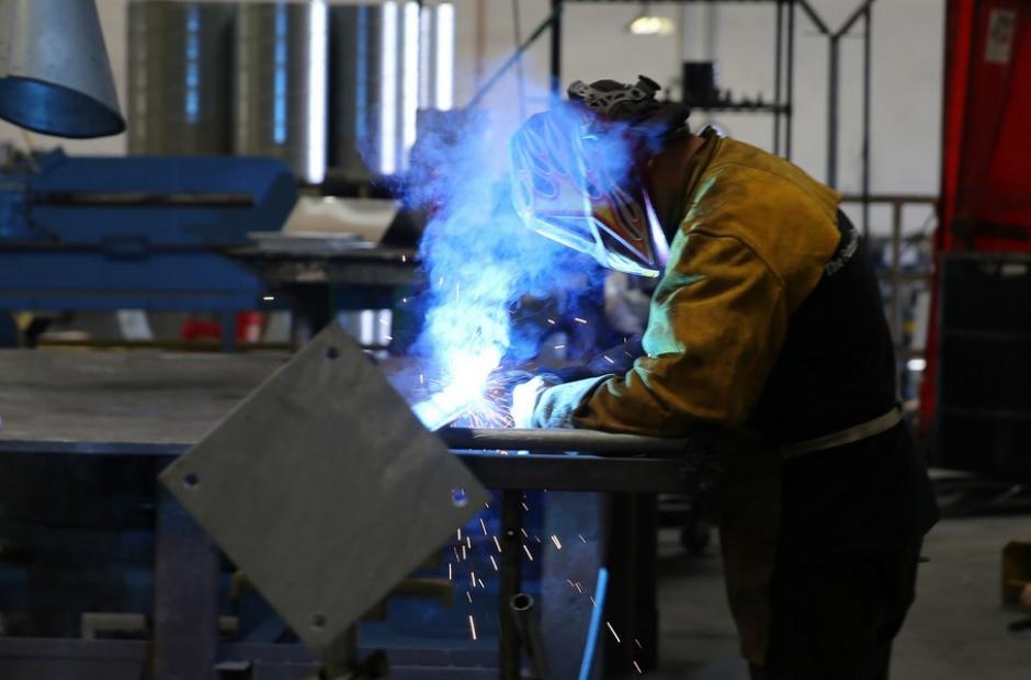 A man spot-welding metal piping.
