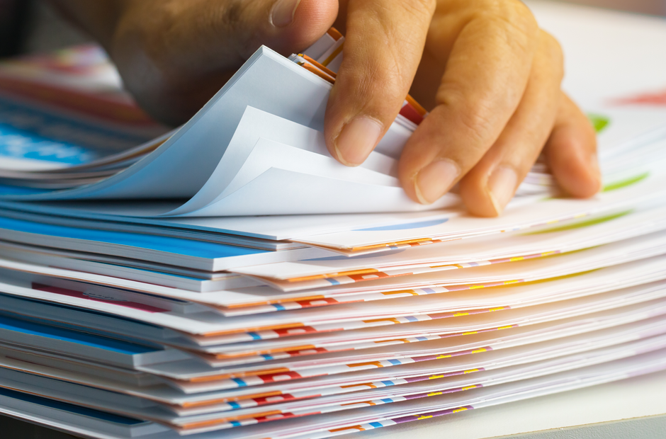 a person going through a pile of paperwork