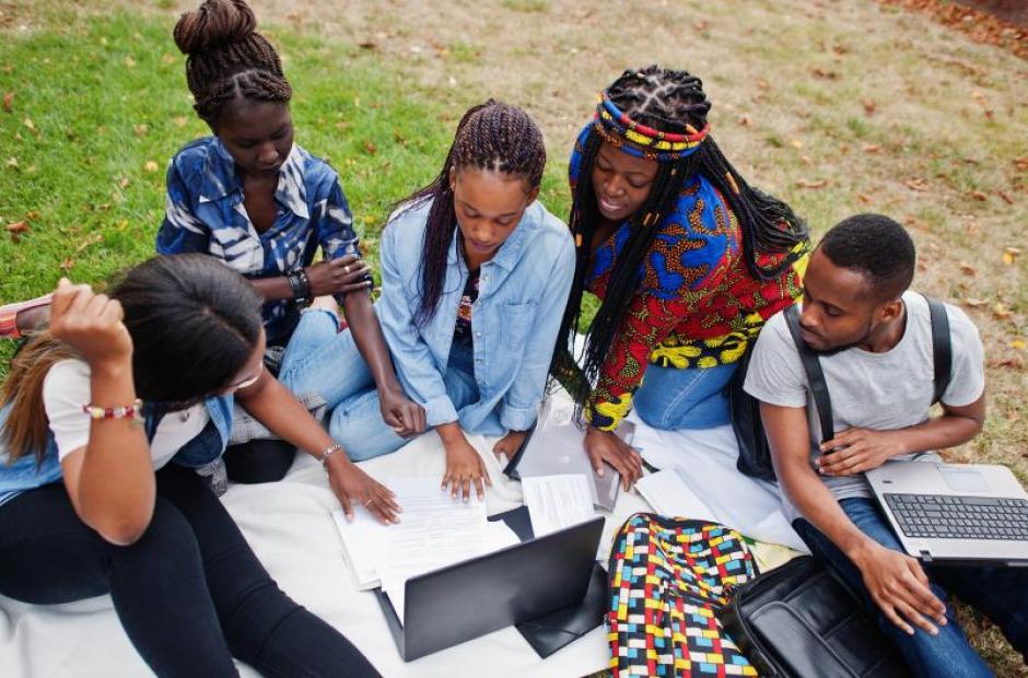 A diverse group of students studying together outdoors.