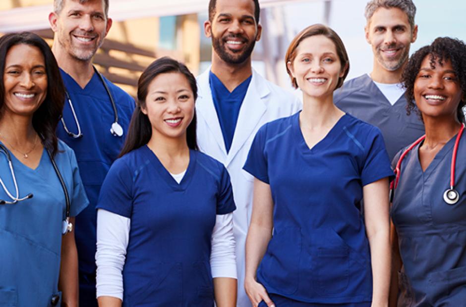 Smiling medical team standing together outside a hospital 