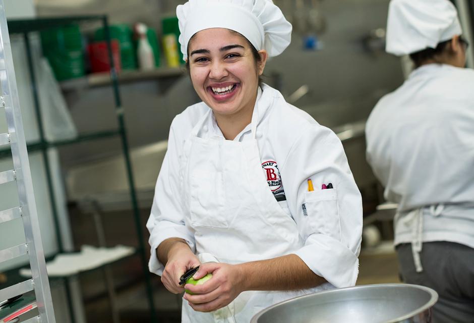 A happy Baking & Pastry Student Peeling Apples
