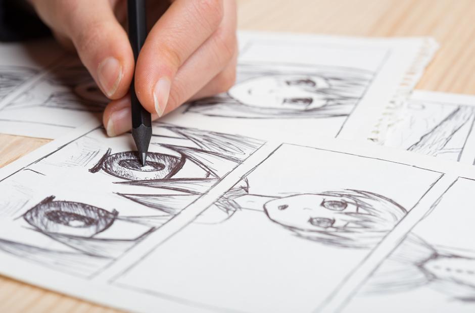 Artist drawing an anime comic book in a studio.