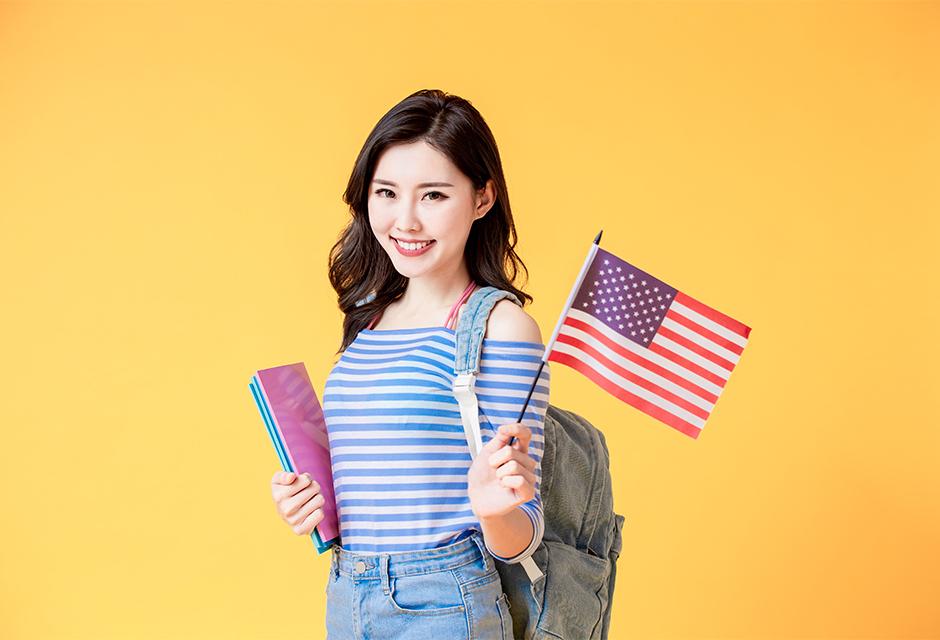 Asian student smiling with an American flag
