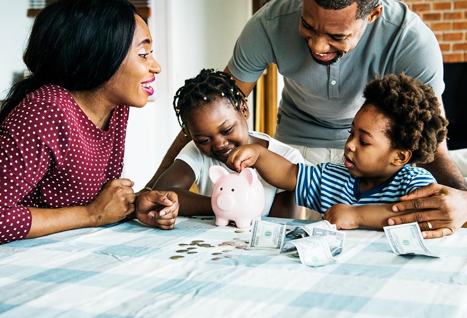 Family saving money to piggy bank 