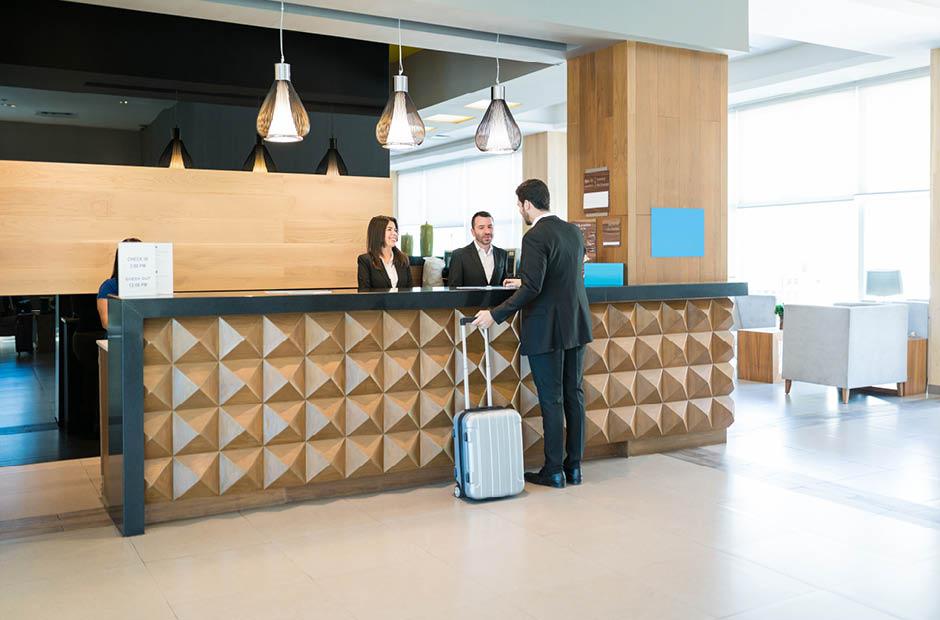 Happy Hotel Clerks Are Welcoming Professional At Counter