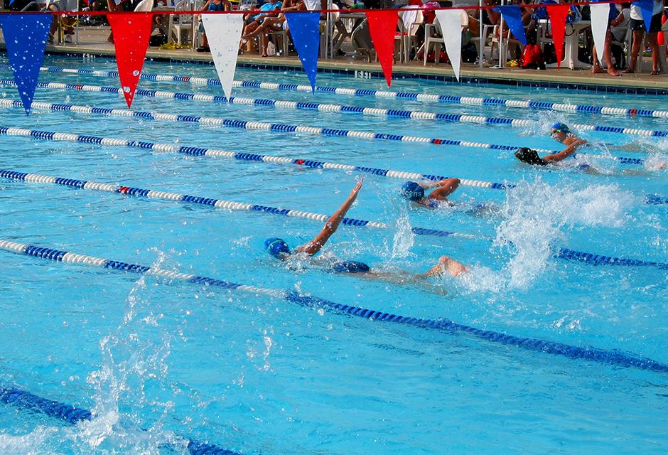 Swimmers racing in their lanes at a competitive meet