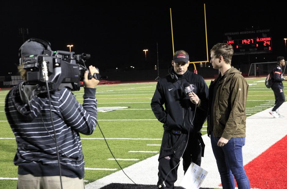 Sports reporter and crew on the football field.