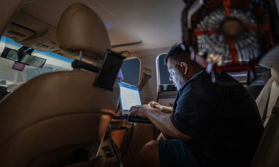 Long Beach City College student Edgar Rosales Jr. works on homework in the back seat of his car. (Barbara Davidson/For The Washington Post)