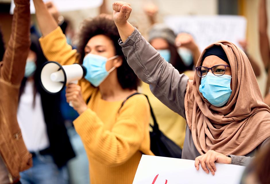 Muslim woman wearing protective face mask while being on a protest against racial discrimination.