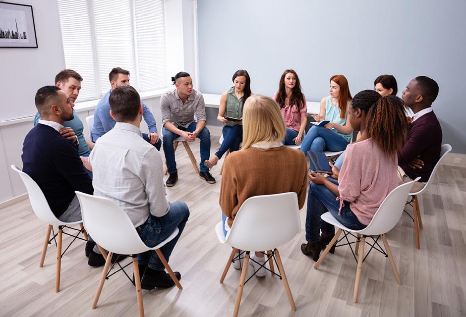 Multi-ethnic People Sitting In Circle Meeting with a Community Organizer