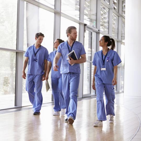 Health care professionals walking down a hallway.