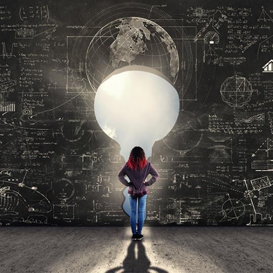 A girl standing in front of a key wall of Math